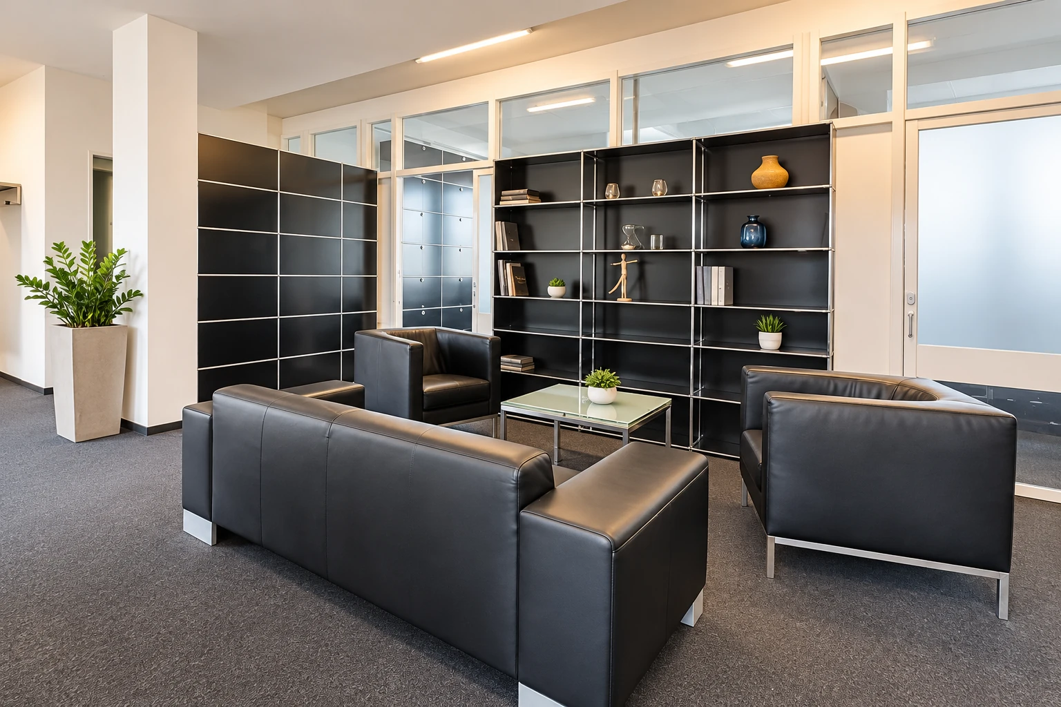 Welcoming PrimeDesk lounge with black leather armchairs, a sofa and a glass coffee table