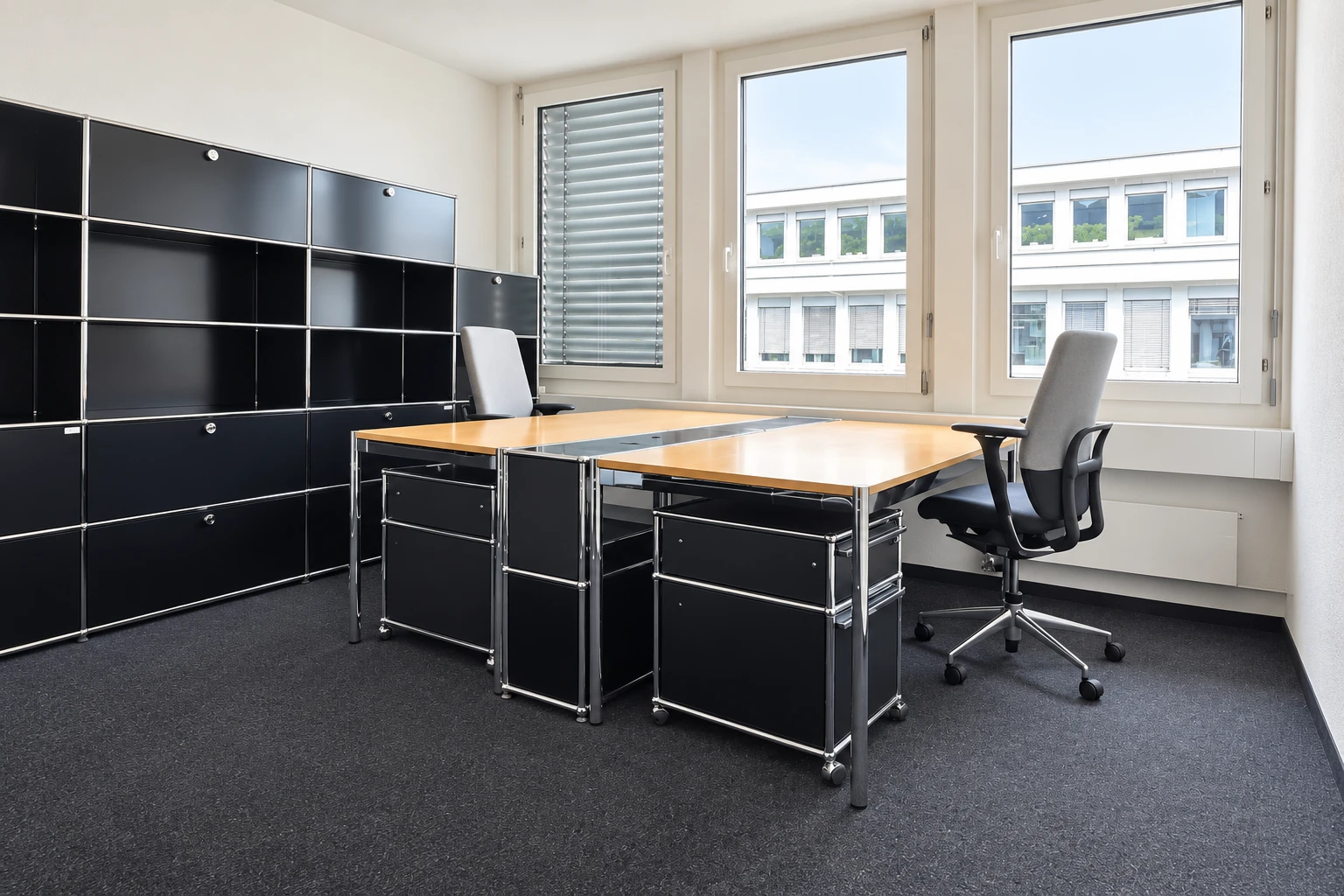 Private office with two wooden desks, grey office chairs and natural daylight